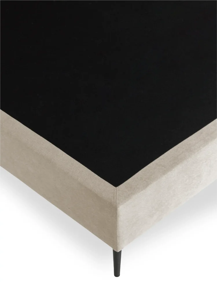 Zoom sur couture et pieds de sommier massif beige
